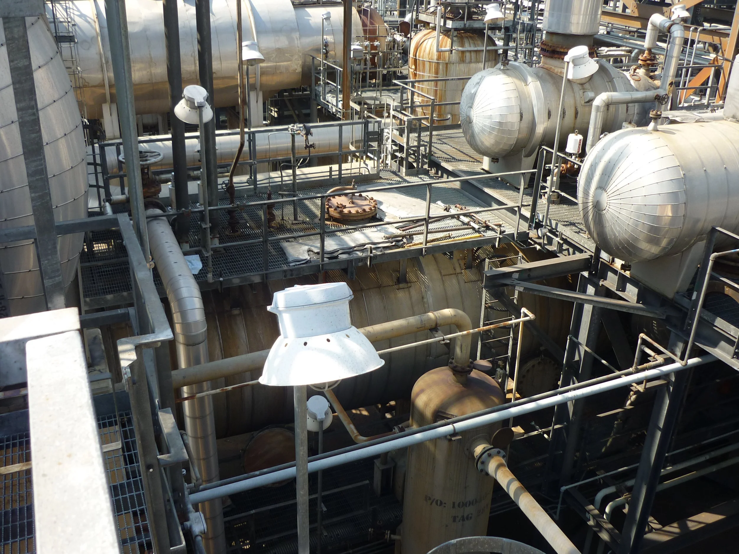 Planta industrial con tuberías y tanques de metal en refineria