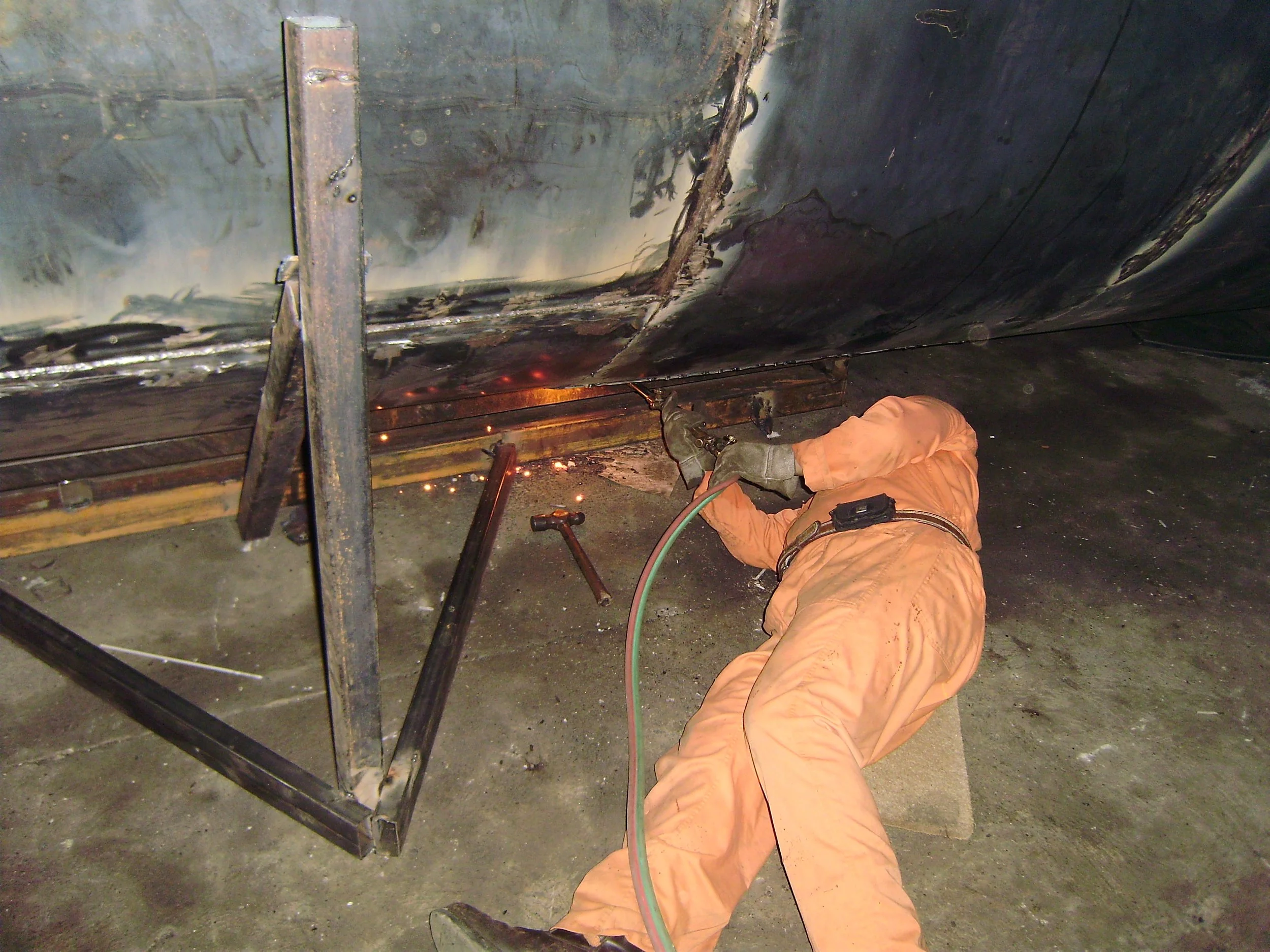 Trabajador soldando una estructura metálica en un taller.