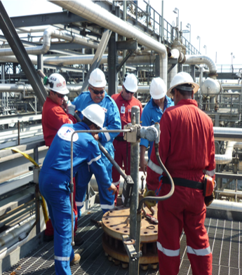Trabajadores en un entorno industrial con equipos de protección en una planta.