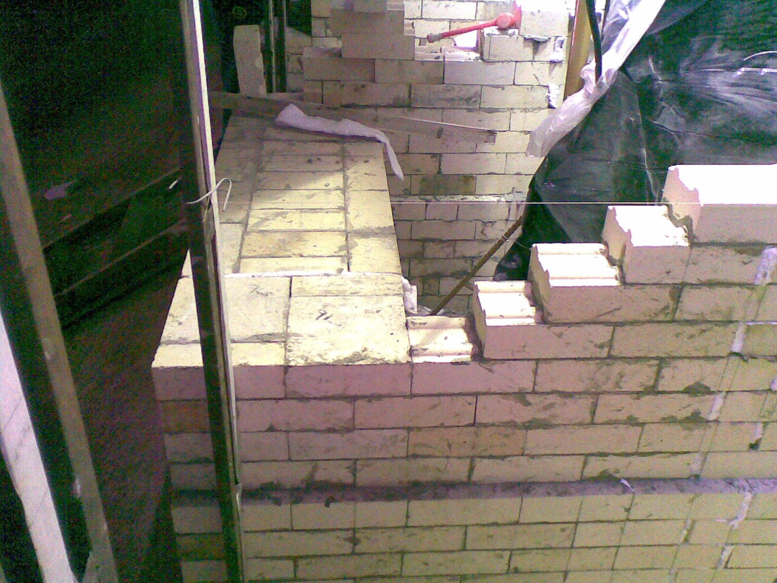 Construcción de una escalera y muro de bloques de ladrillo en obra en progreso.