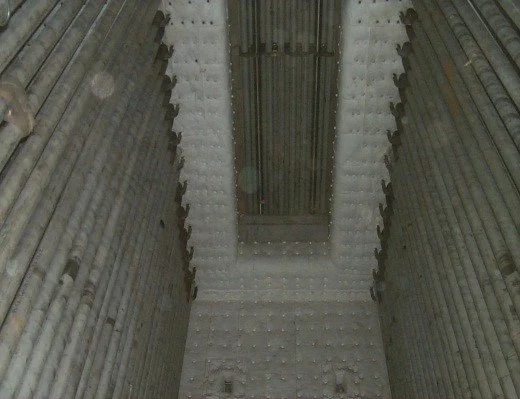 Vista del interior de una mina subterránea con paredes de roca y una vía de tren en el techo.