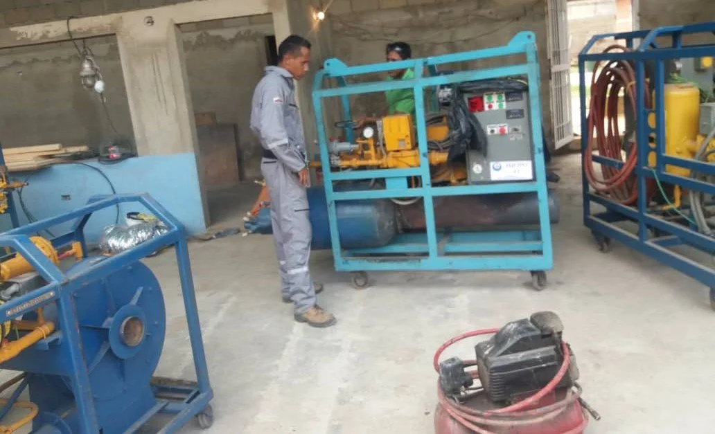 Personas en un taller industrial trabajando con maquinaria y equipo técnico.