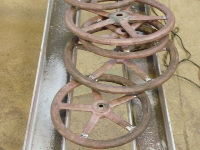 Cuatro llaves oxidadas colocadas sobre una mesa de trabajo metálica.