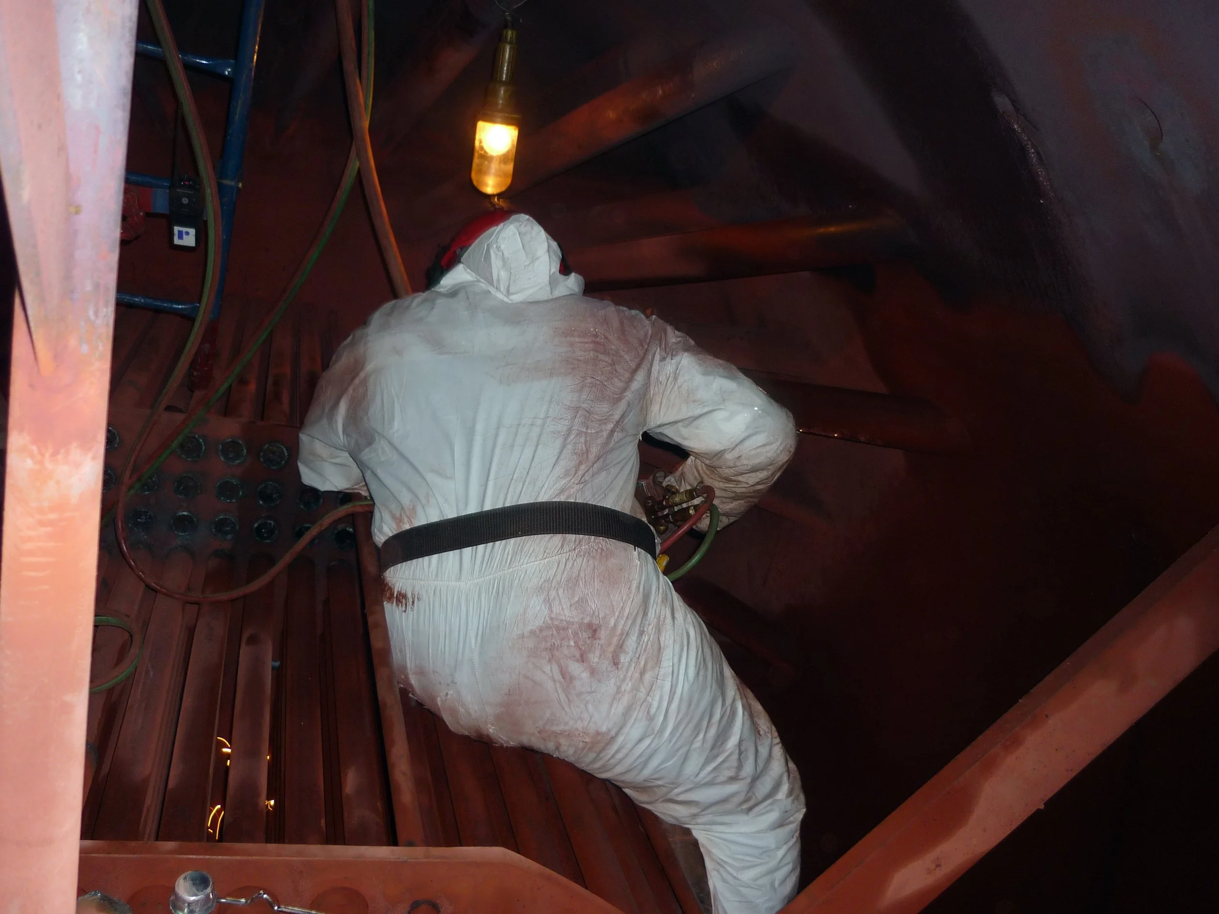 reentubado. Trabajador con equipo de protección utilizando una herramienta para intercambiador de calor .