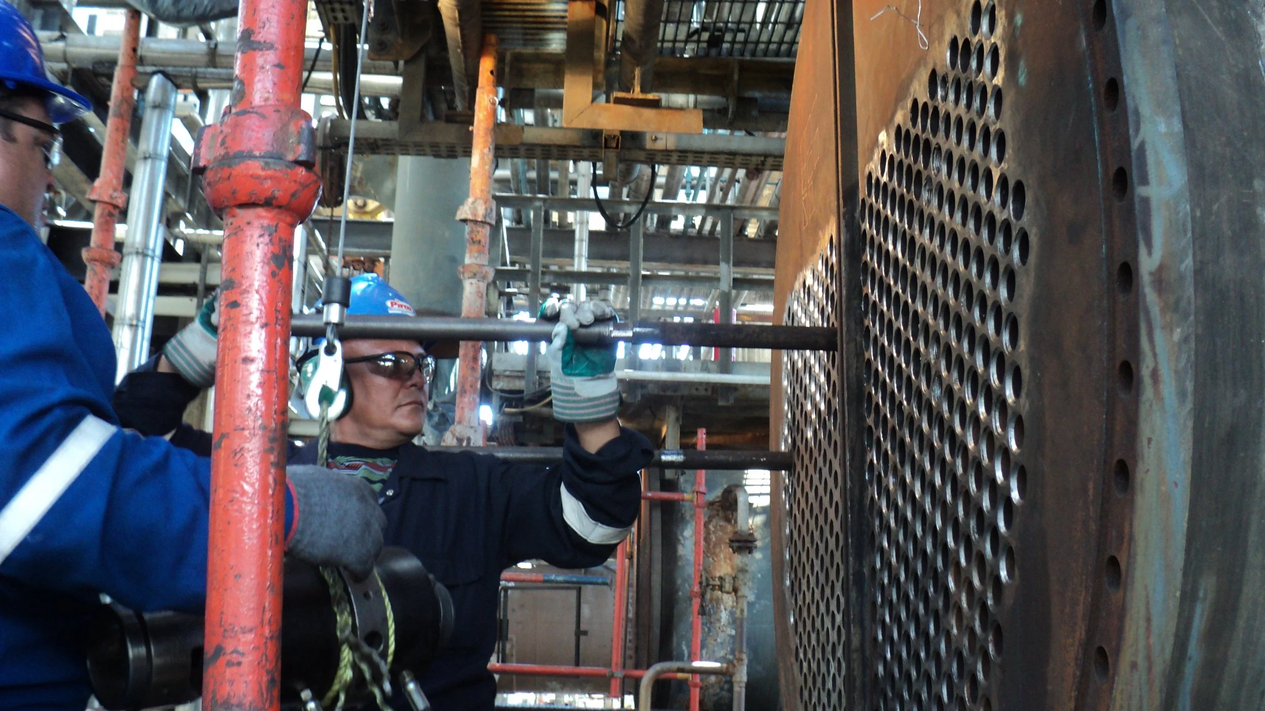 Persona trabajando reentubado de un intercambiador de calor.