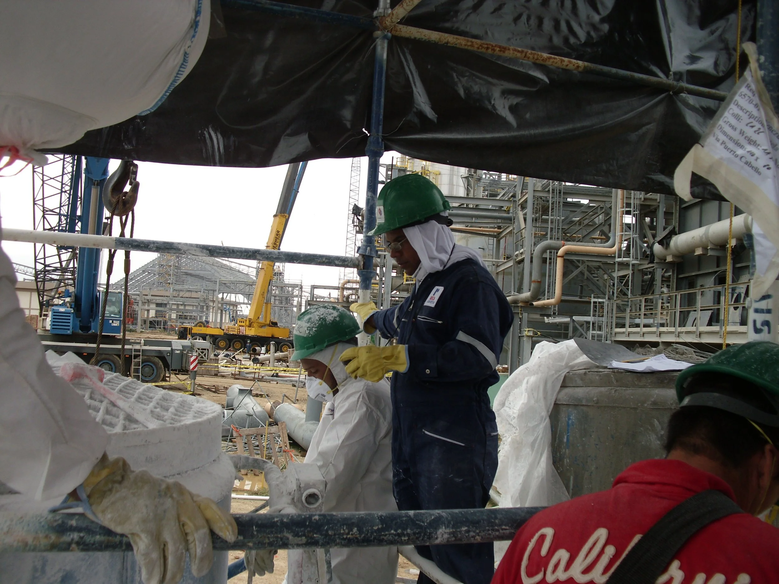 vaciado de reformador secundario. Trabajadores con cascos y equipo de seguridad en una construcción industrial 