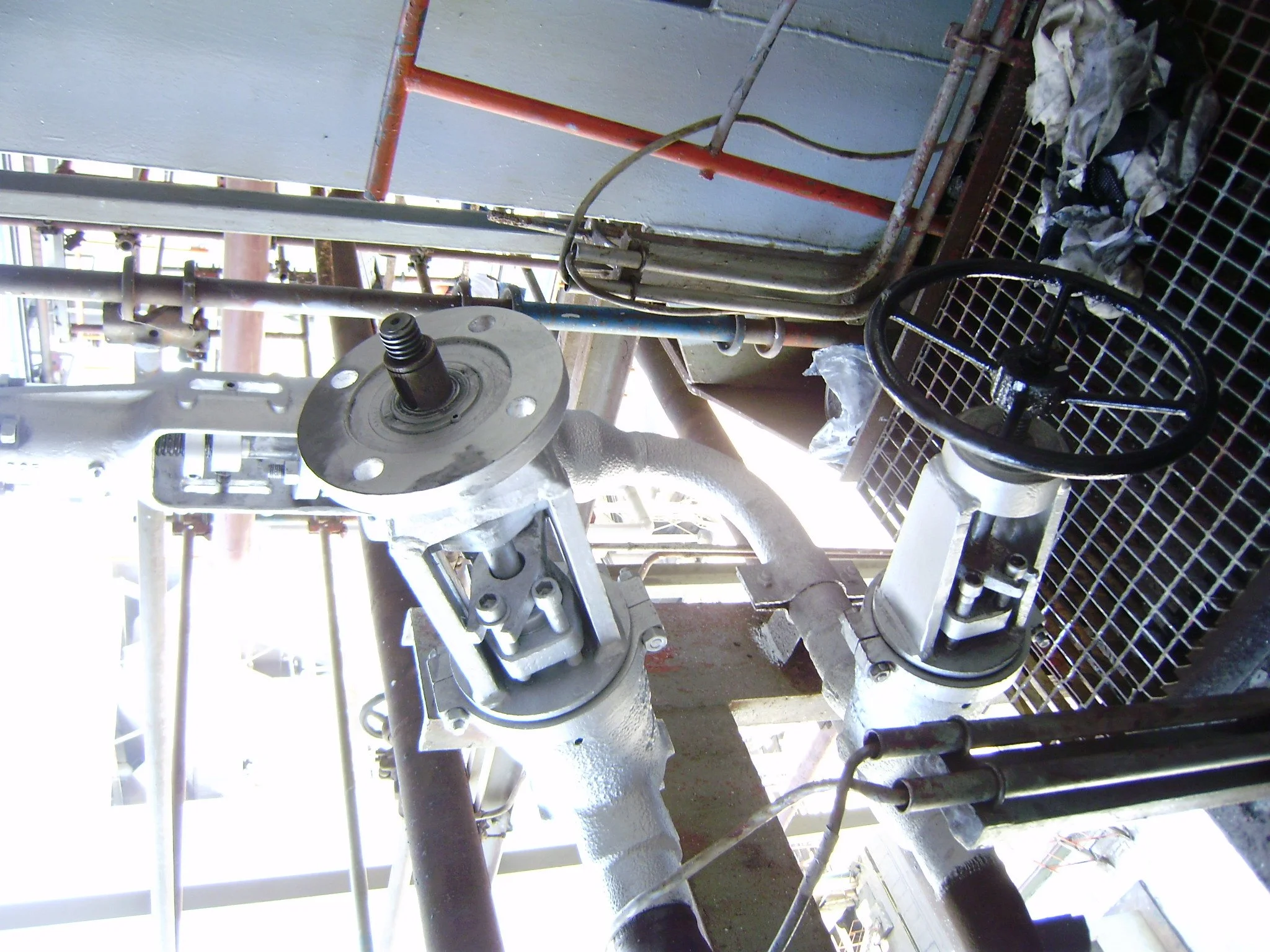 Estructura metálica con válvula y manómetro en un entorno industrial.