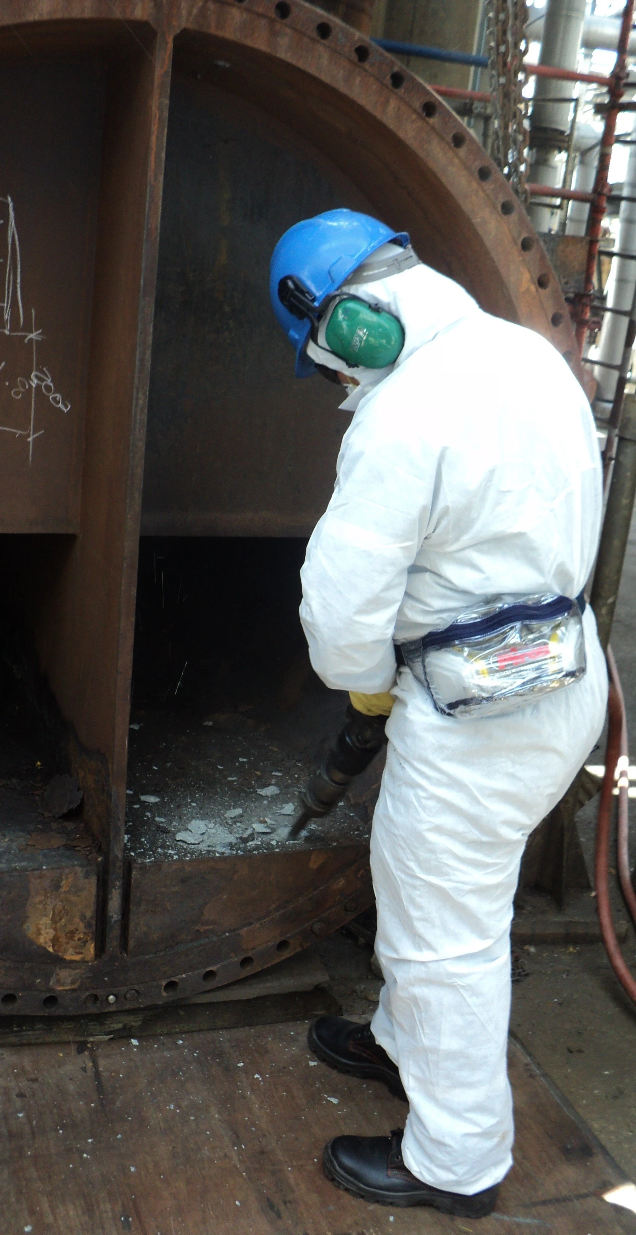 reentubado. Trabajador con equipo de protección utilizando una herramienta para intercambiador de calor .