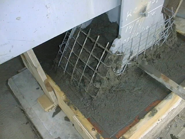 enconfrado  de madera con un marco de metal y malla de alambre, en construcción o reparación, en un área de trabajo con sombra.