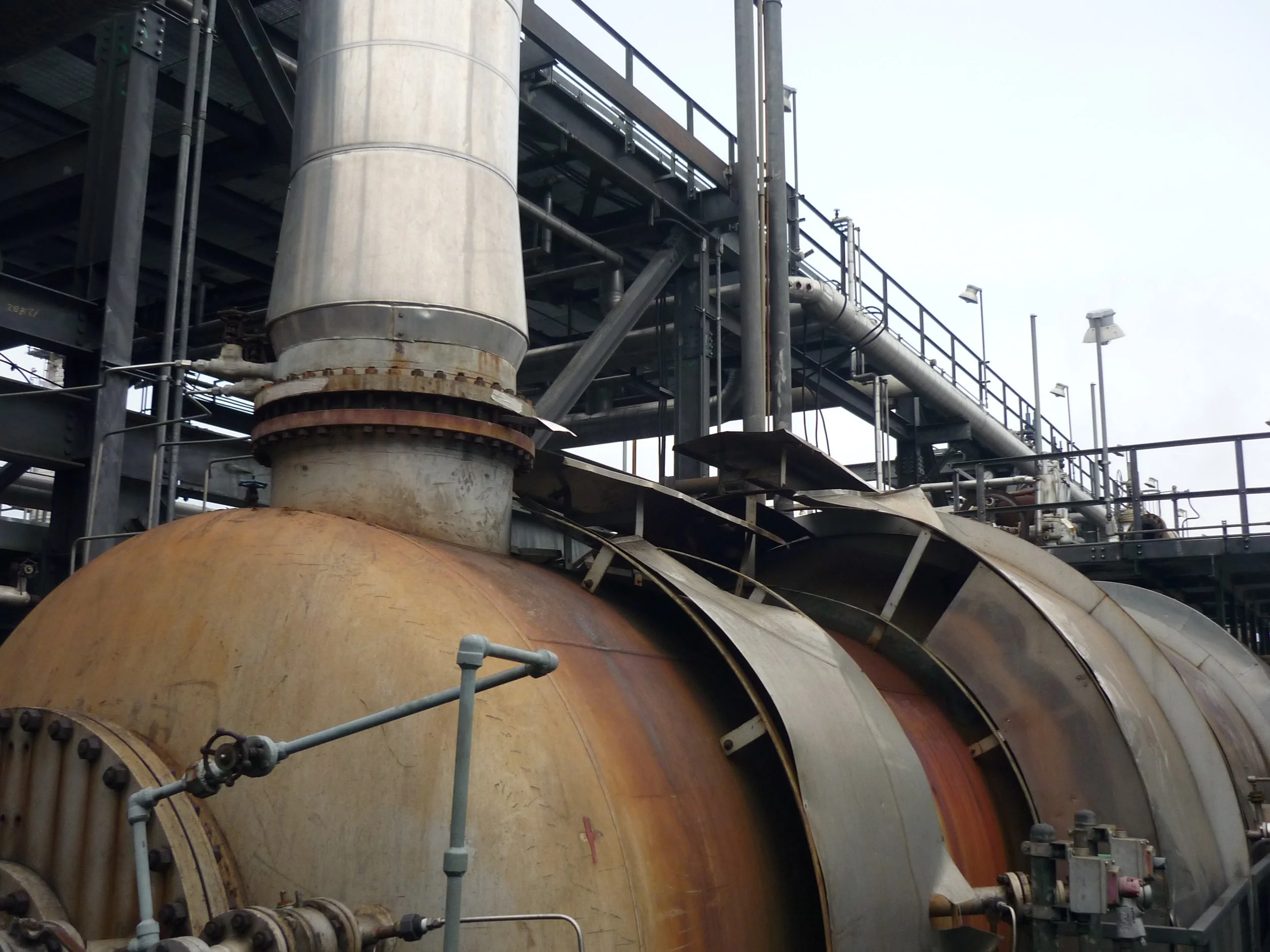 Estructuras metálicas, tuberías y maquinaria industrial en una planta o refinería.