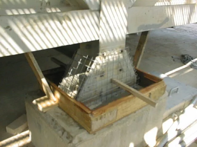 enconfrado  de madera con un marco de metal y malla de alambre, en construcción o reparación, en un área de trabajo con sombra.