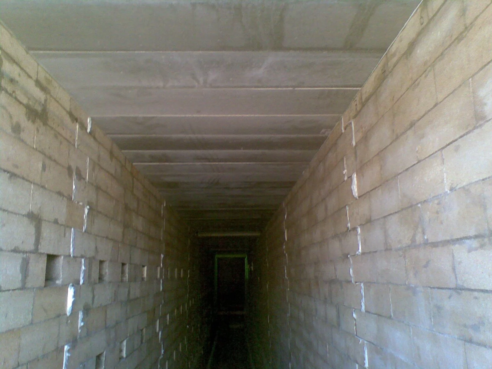 Pasillo en construcción con paredes de ladrillo y techo de concreto