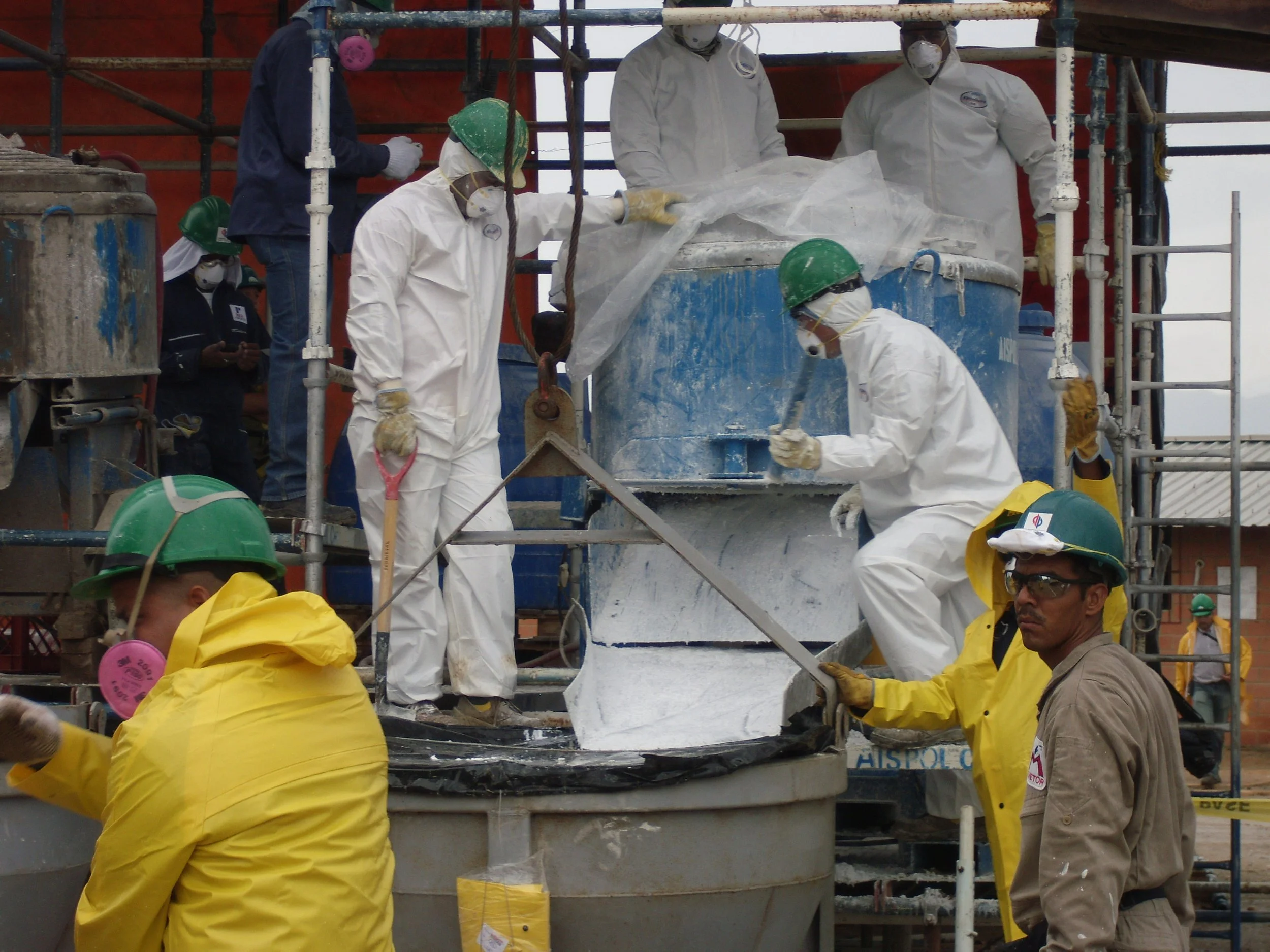 vaciado de reformador secundario. Trabajadores en un sitio de construcción en planta petroquimica, mezcladora material refractario, andamios y equipo de seguridad
