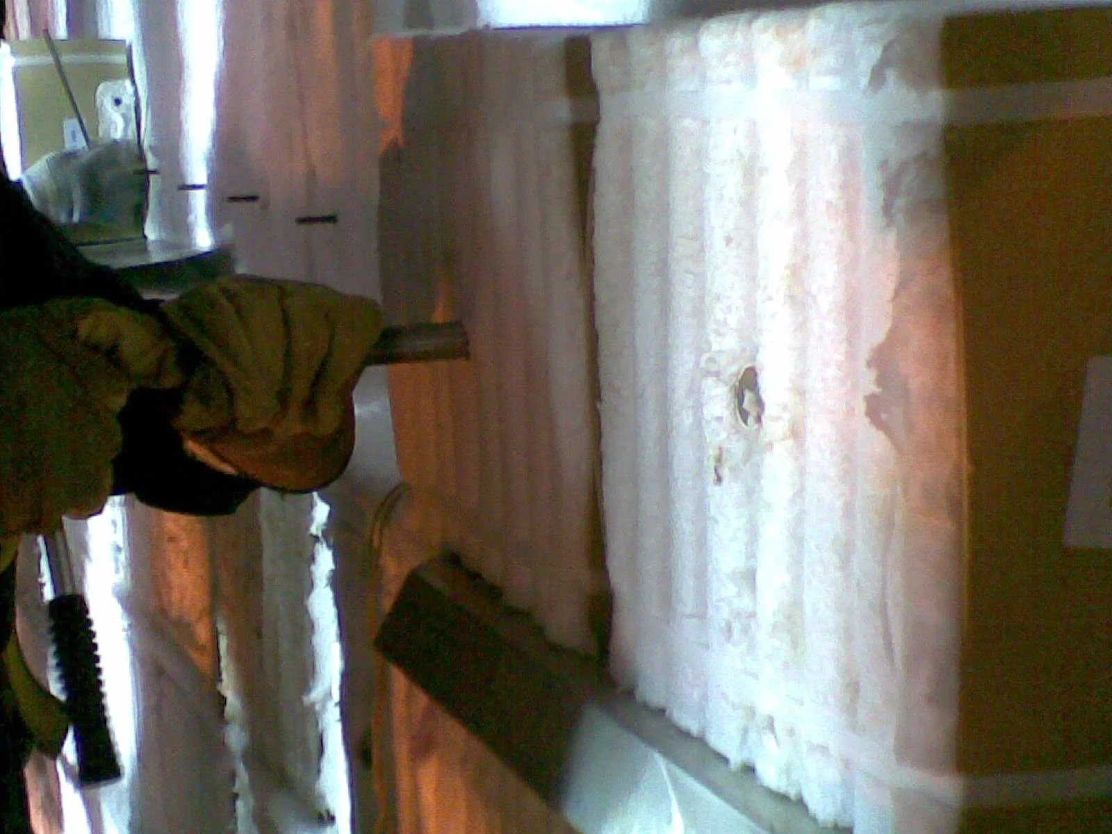 Persona instalando fibra ceramica con herramientas en una pared 