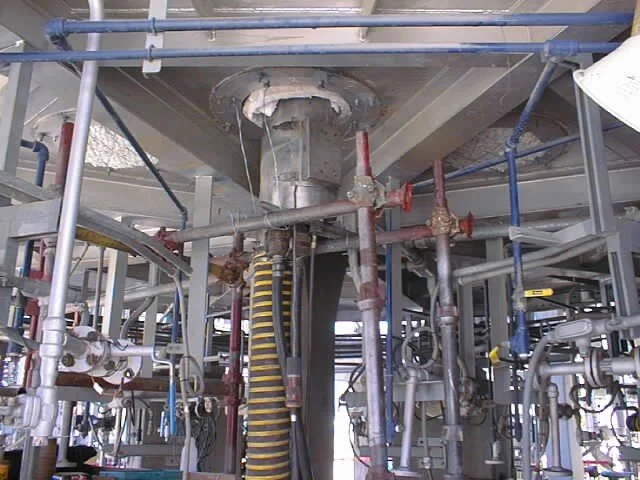 Estructura metálica y tuberías en una instalación industrial, posiblemente una planta química o de procesamiento.
