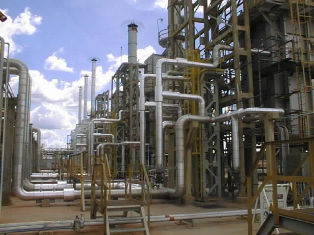 Plantas industriales con tuberías de acero y estructuras metálicas.