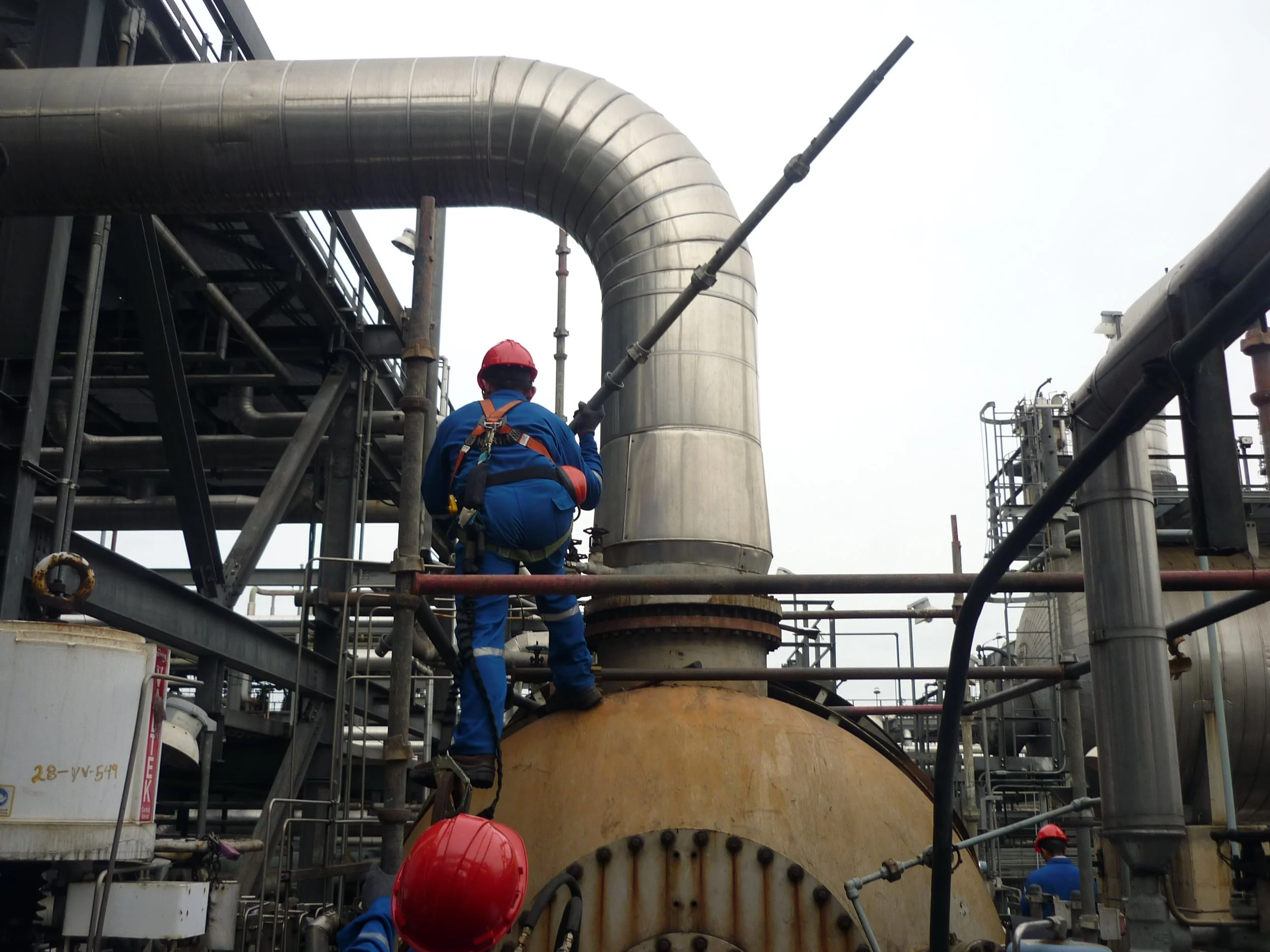 trabajadores en un entorno industrial, armando andamio