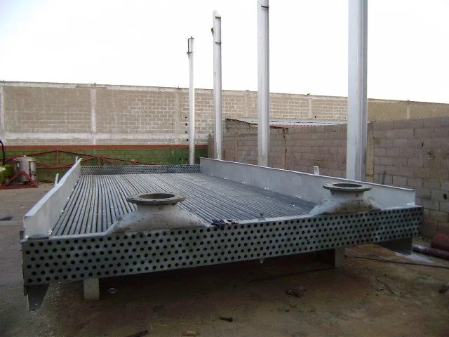 	
Intercambiadores de calor, Vigas de metal de color plata apoyadas sobre caballetes de madera en un taller