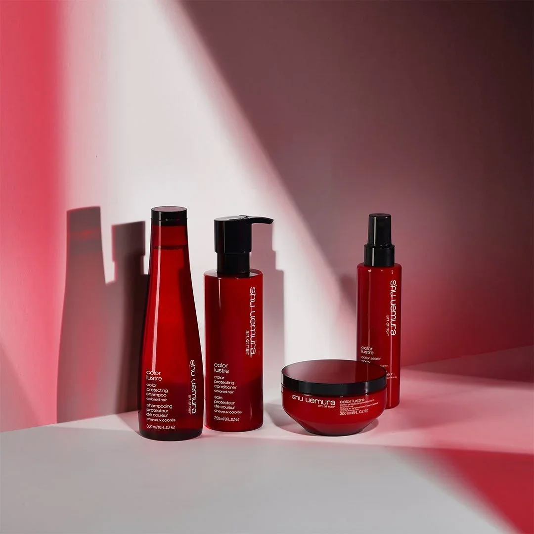 Red hair care products including shampoo, conditioner, hair mask, and leave-in treatment from Shu Uemura Art of Hair line.