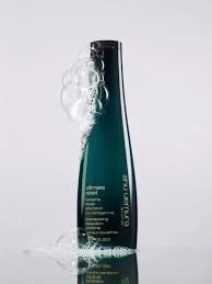 A black bottle of shampoo with foam around its neck, standing upright against a light background.