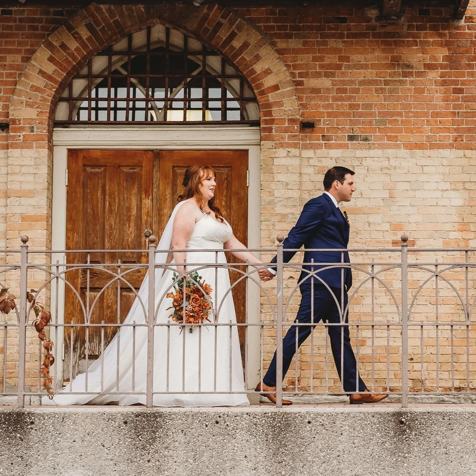 bride and groom walking at old court house in London Ontario