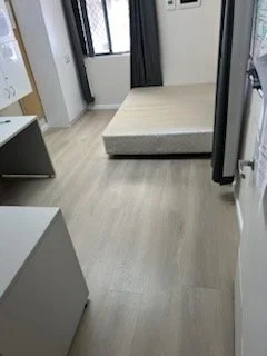 Unmade bed with mattress on the floor in a small room