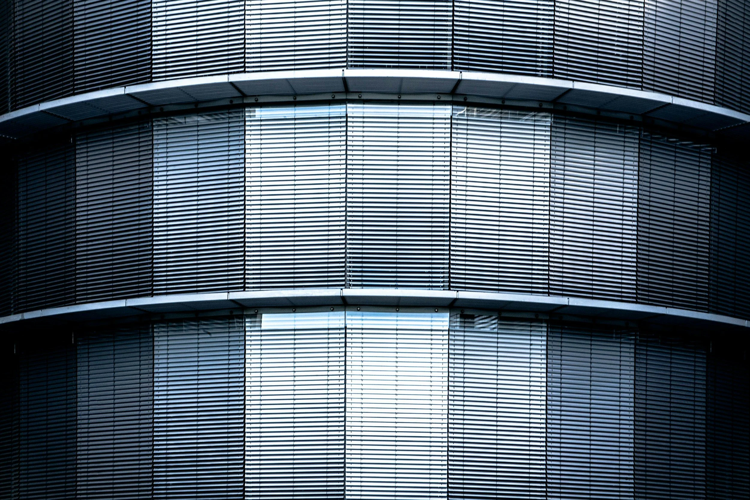 Close-up of a modern building's exterior with horizontal and vertical metal louvered panels