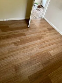 Empty room with wood flooring and a white door frame.