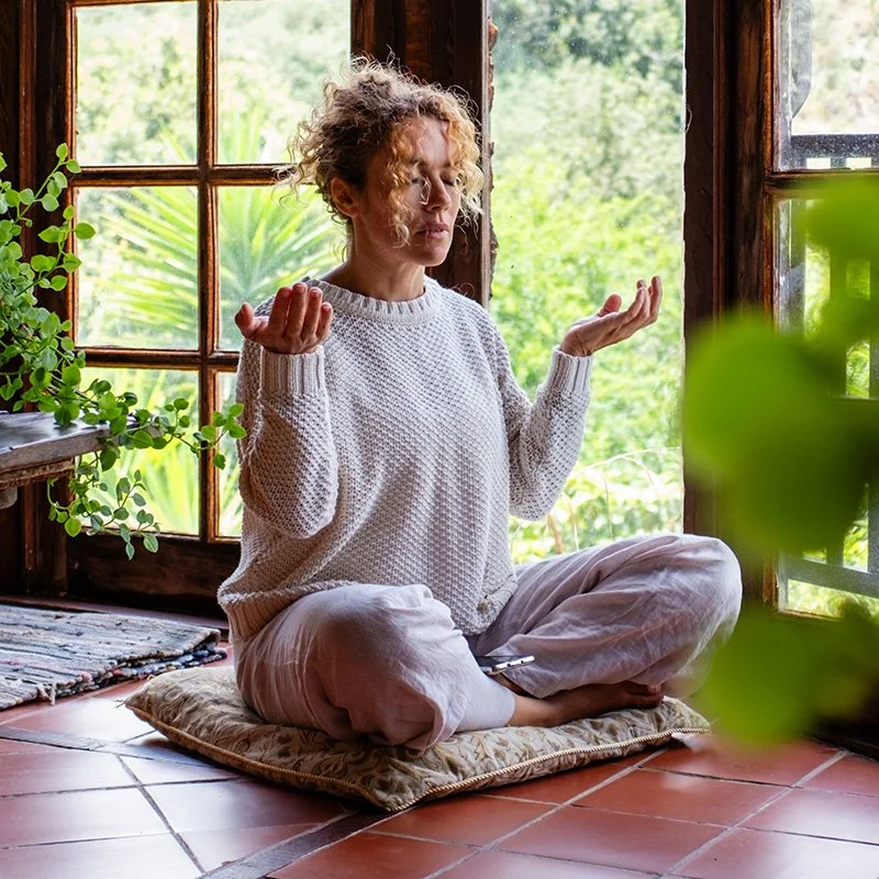 woman sitting on a pillow during a yoga session