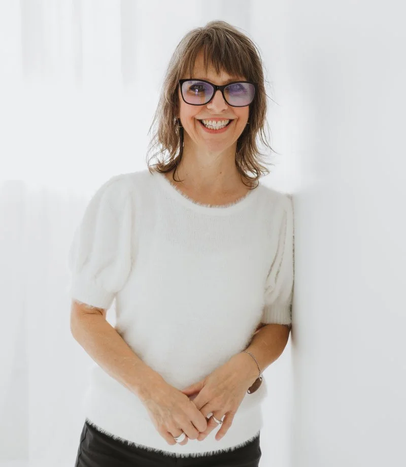 Heather smiling leaning against a wall