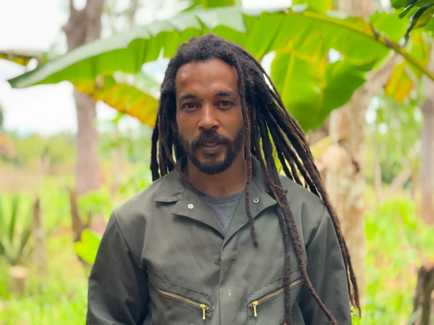 A speaker discussing agriculture among banana plants.