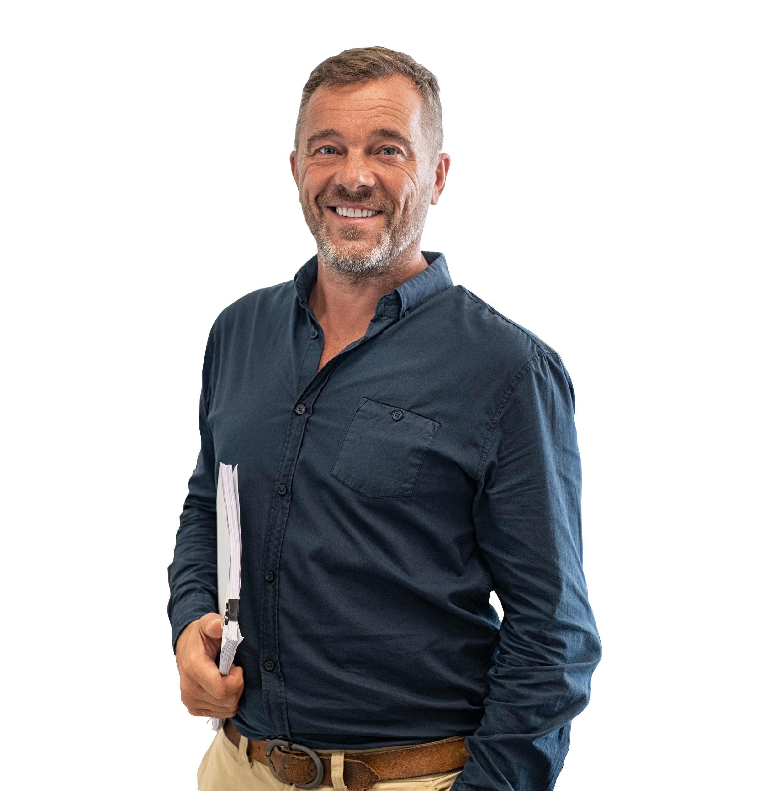 Smiling man in blue shirt holding papers against a white background.
