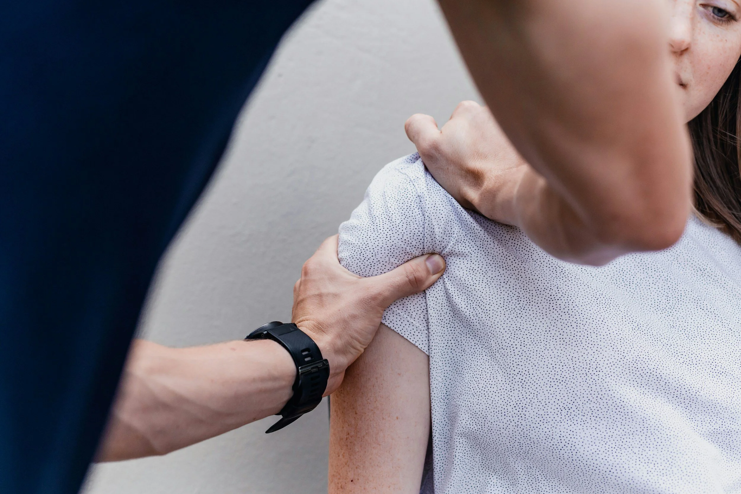 Close-up of a person's shoulder receiving a vaccination or shot from a healthcare professional