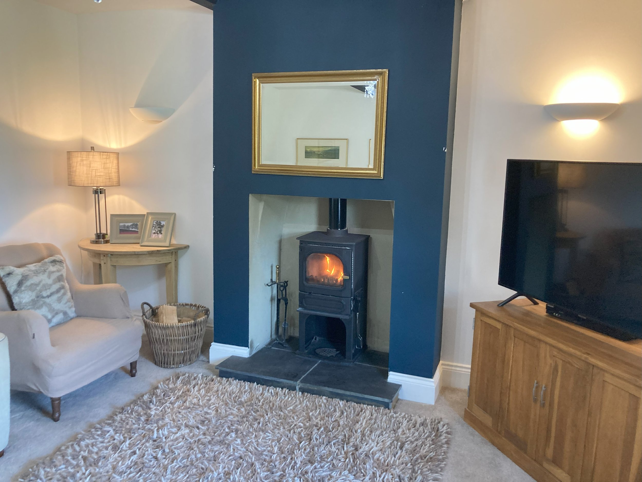 Clayfield Farmhouse living room log burner next to tv