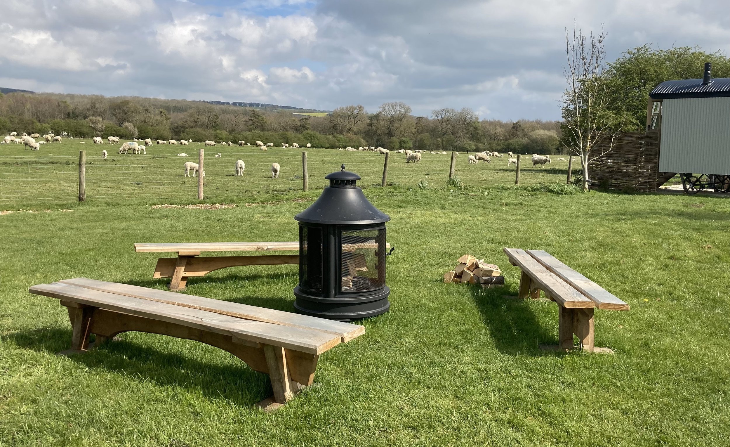 Clayfield Farm shepherd's huts outdoor area with fire pit and benches