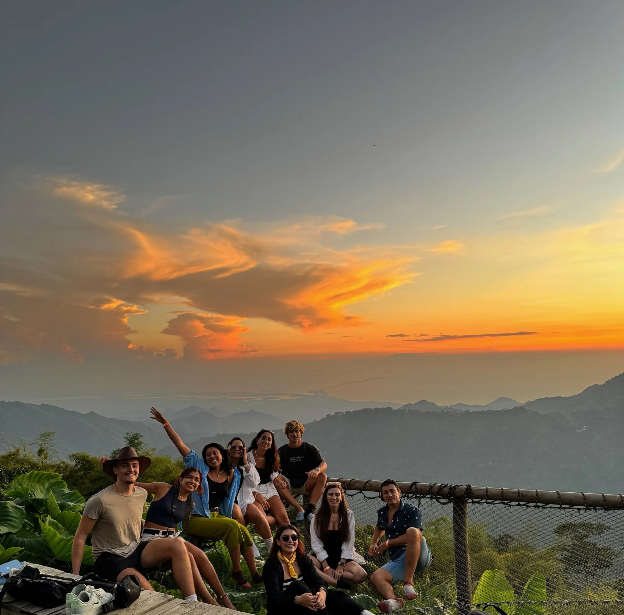Group of people taking a photo with mountains and a sunset in the background. Minca, Santa Marta, Colombia