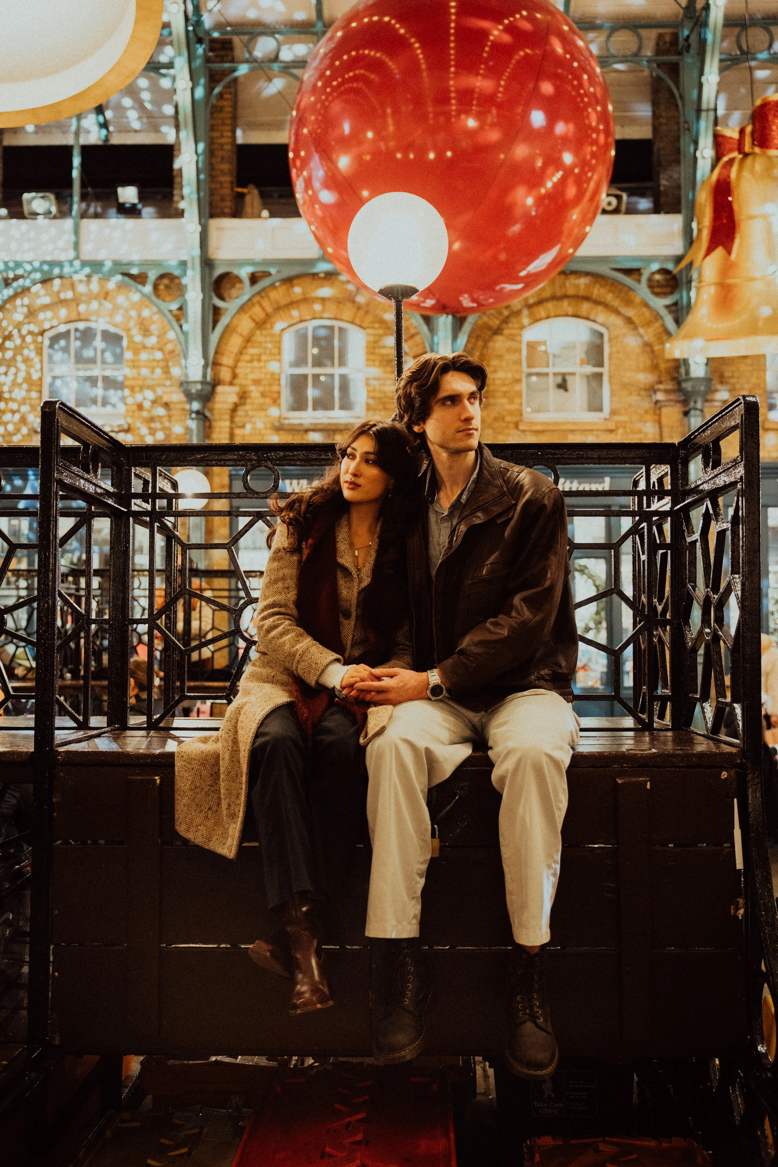 London couple sitting hand in hand in Covent Garden in London