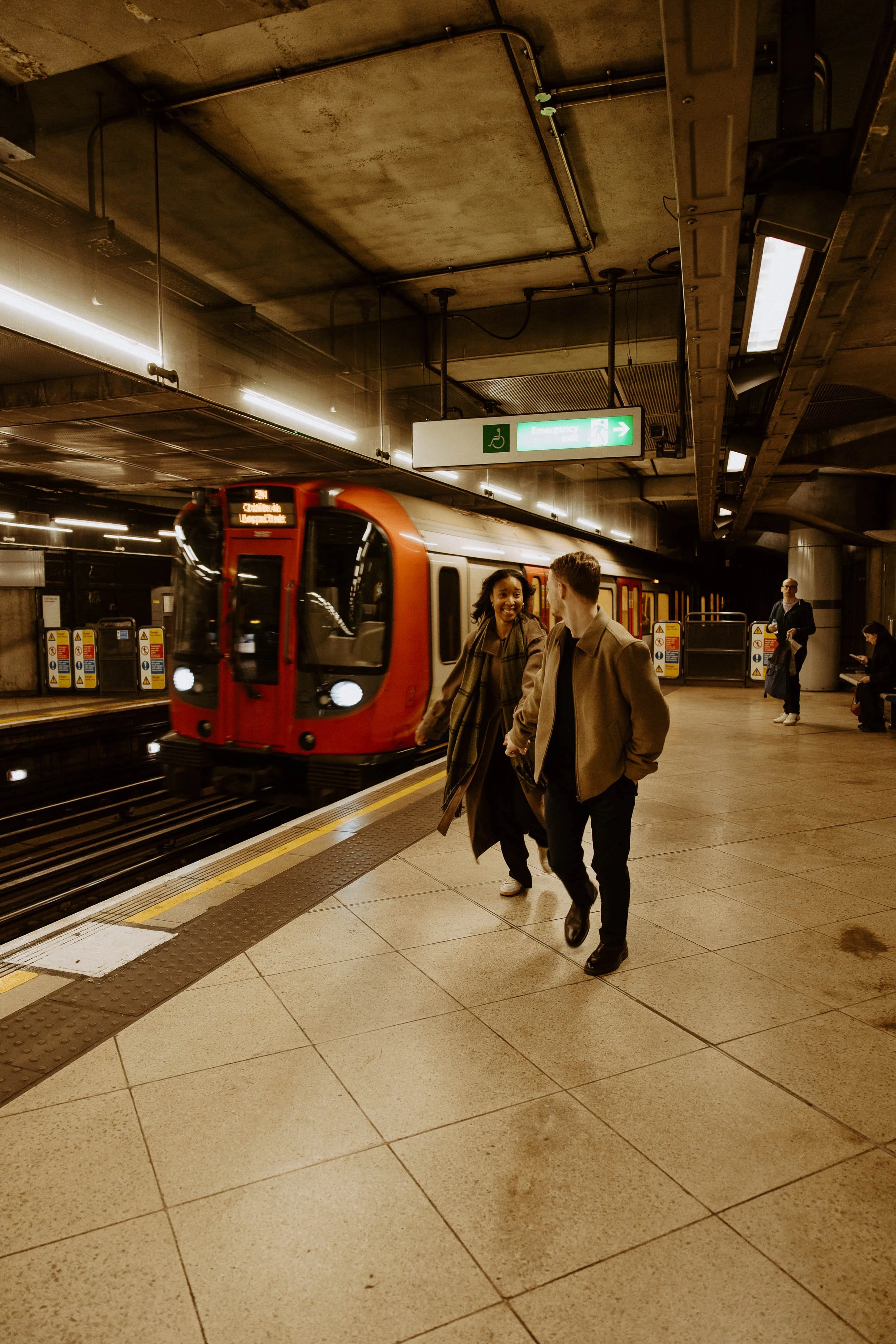 Amira and Caleb running hand in hand in the Underground