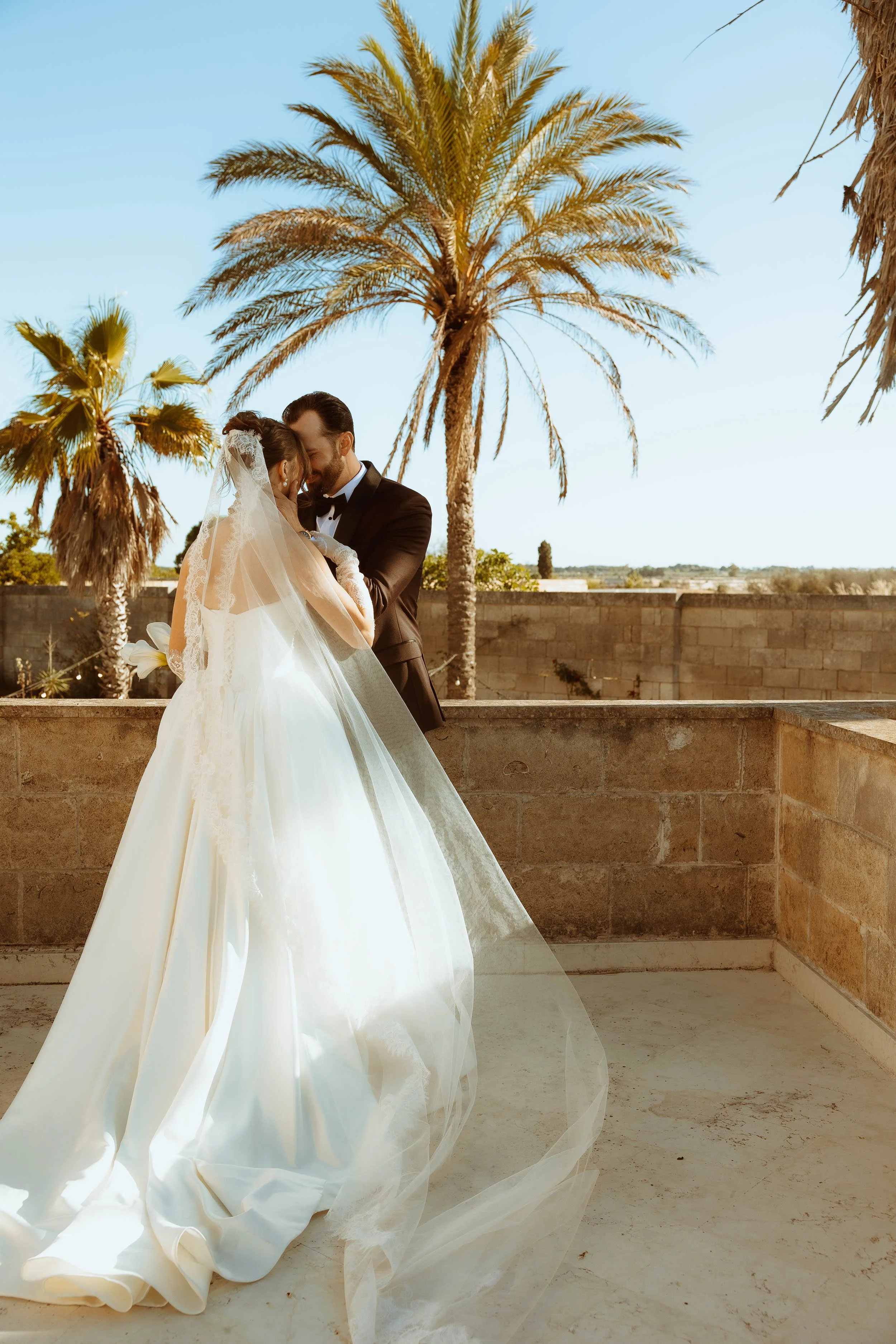 Matt and Rosalinda pose in wedding attire overlooking the Puglia countryside