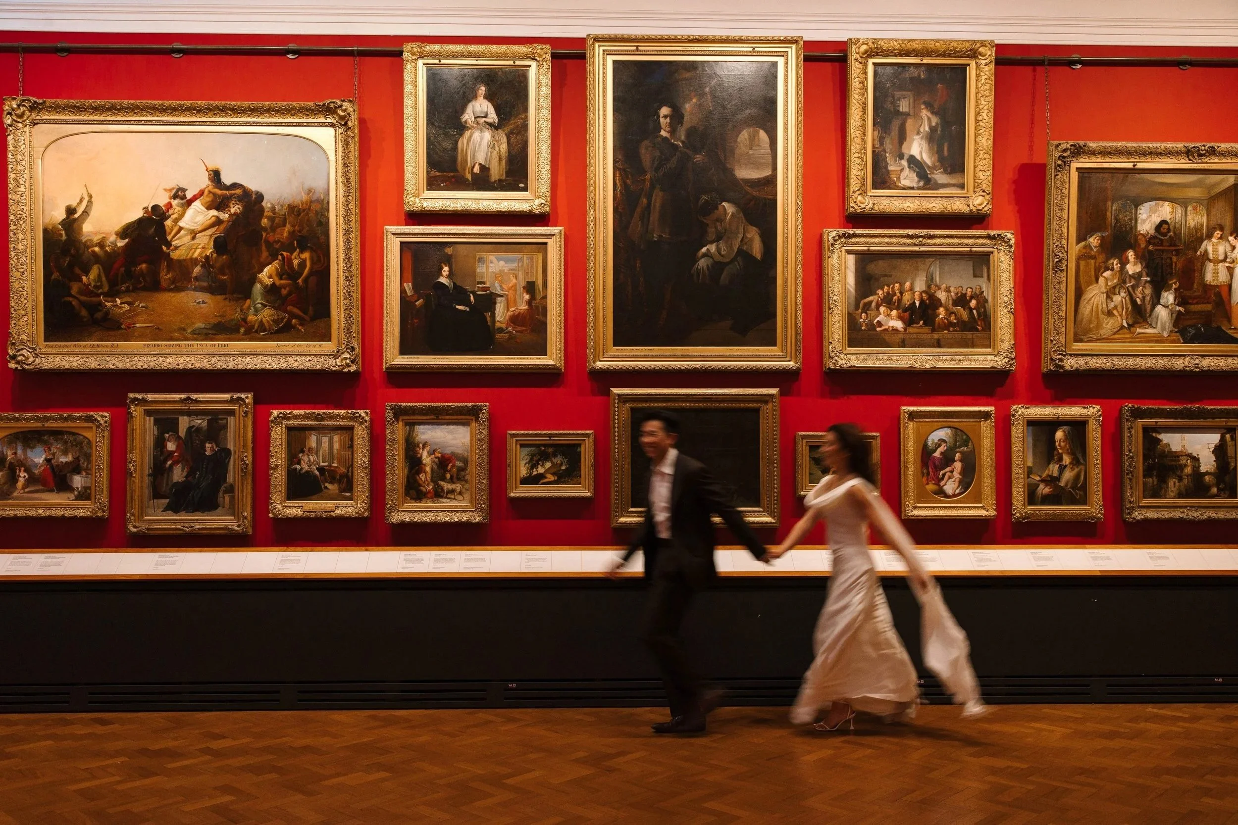 An artfully blurry shot of Justice and Candace walking through an art museum holding hands