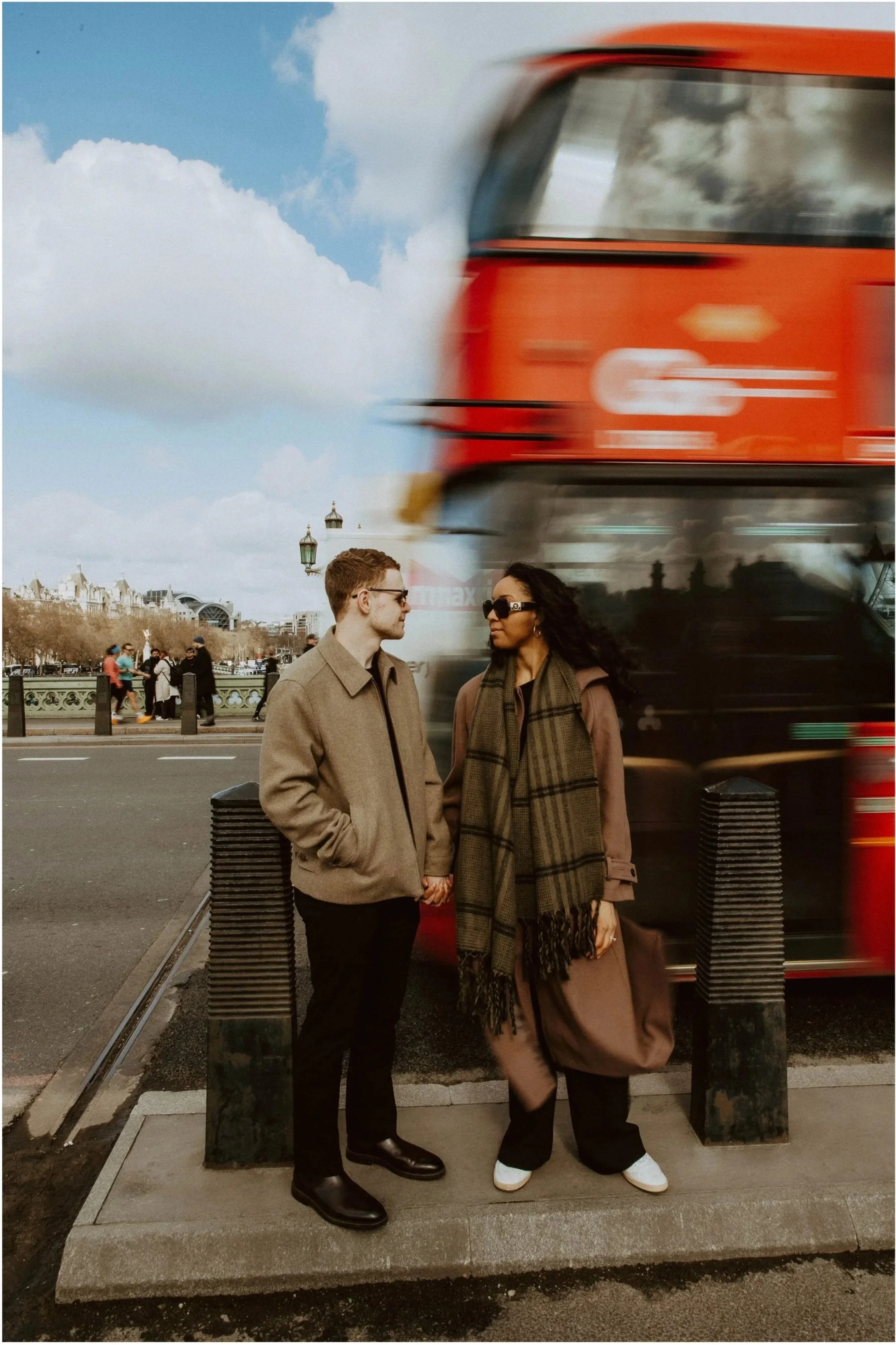 Amira and Caleb with a red bus blurred behind them