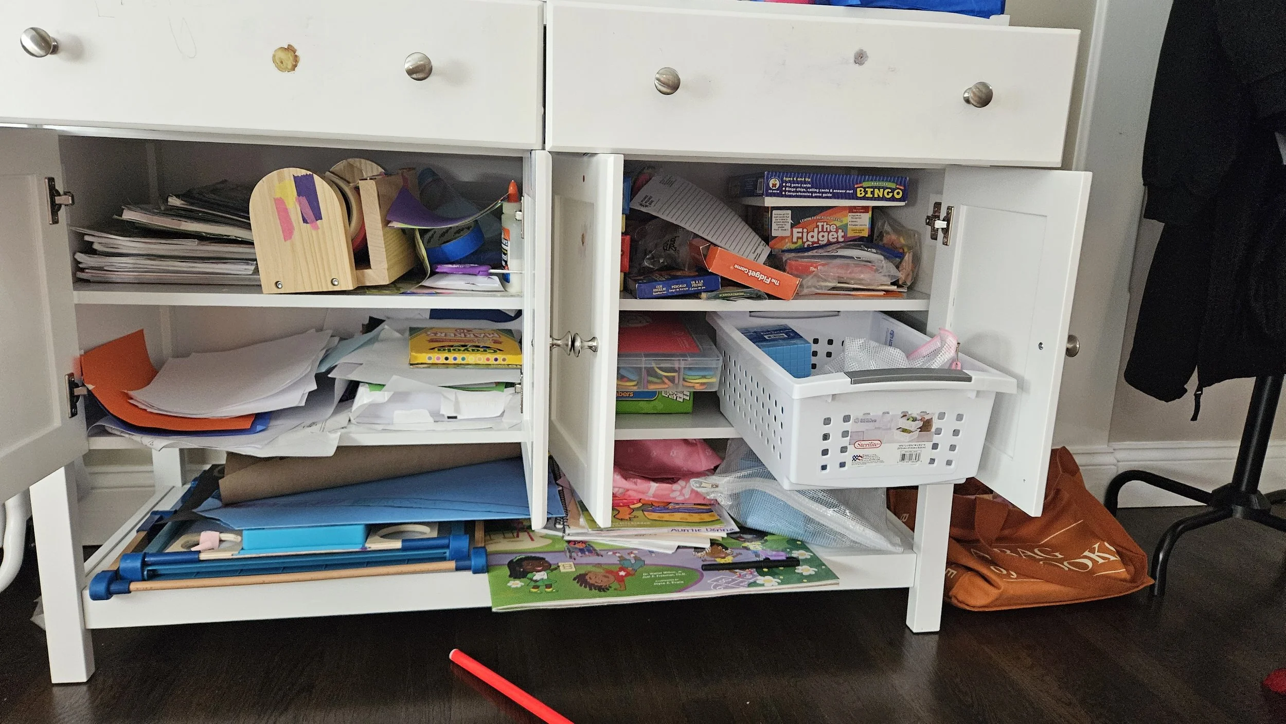Messy craft cabinet before being organized.