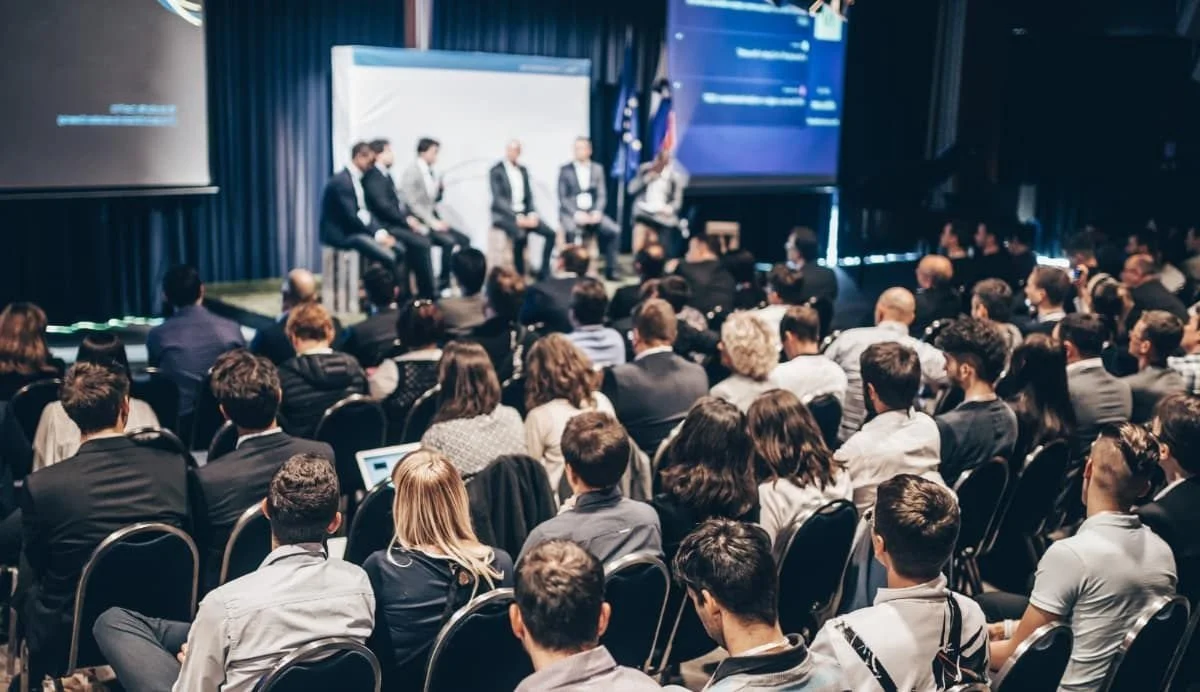 Close-up view of an audio mixing console with faders, knobs, and buttons.
