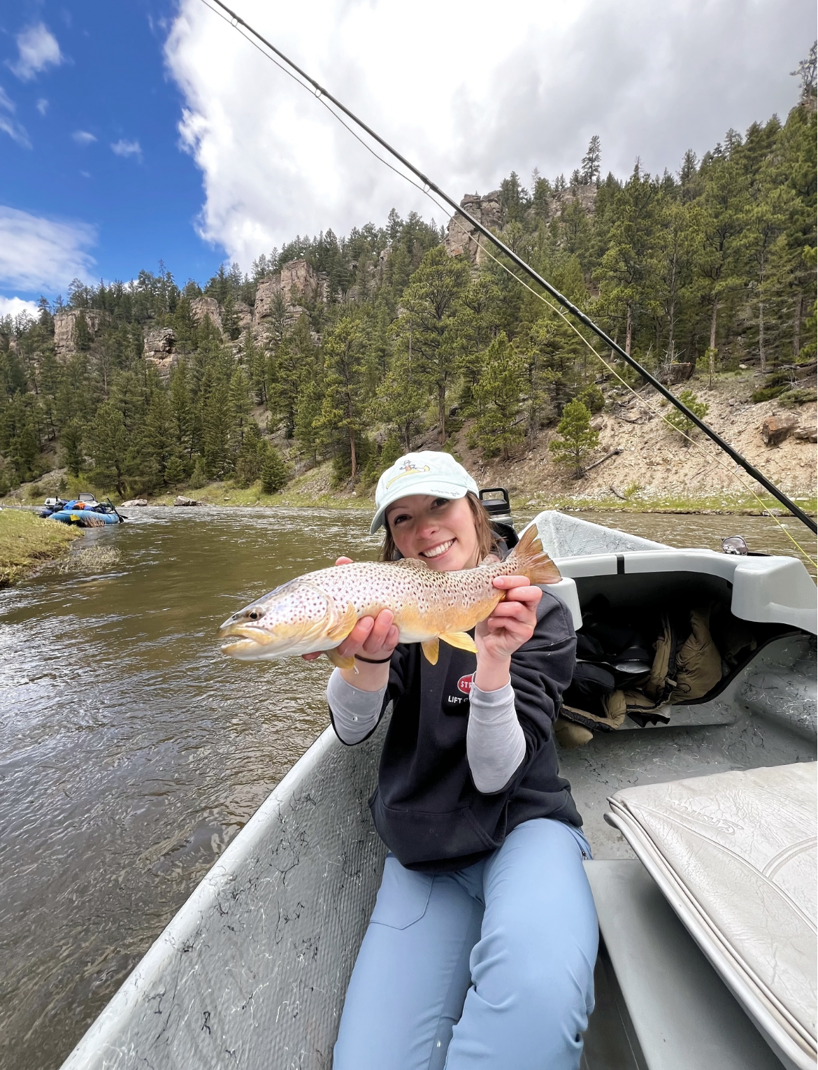 Picture of Marri holding up a fish on a drift boat