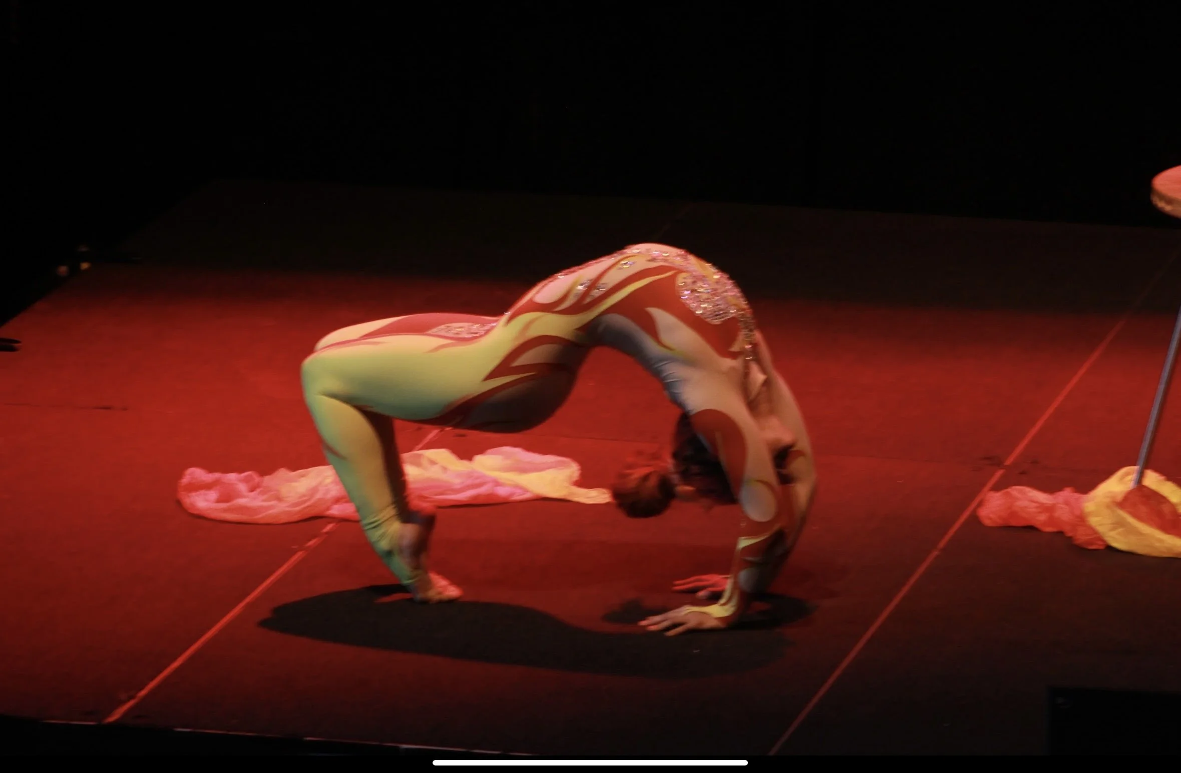 Talia Hazard holding a low backbend under red stage lights