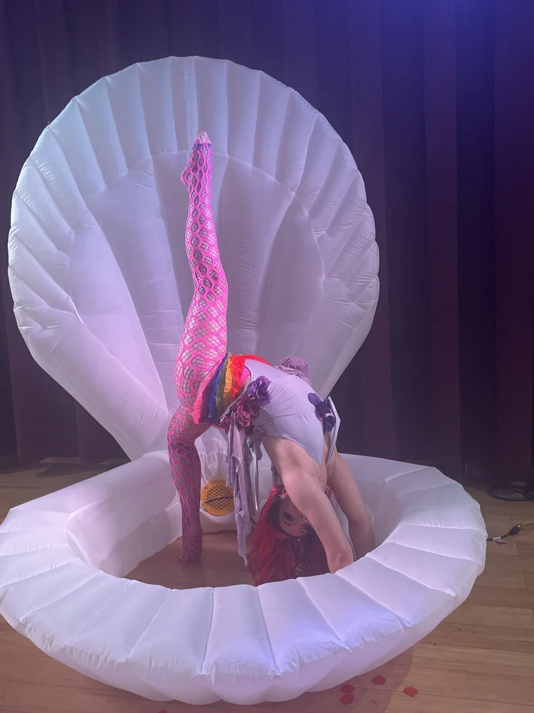 Talia Hazard performing in front of a large illuminated shell