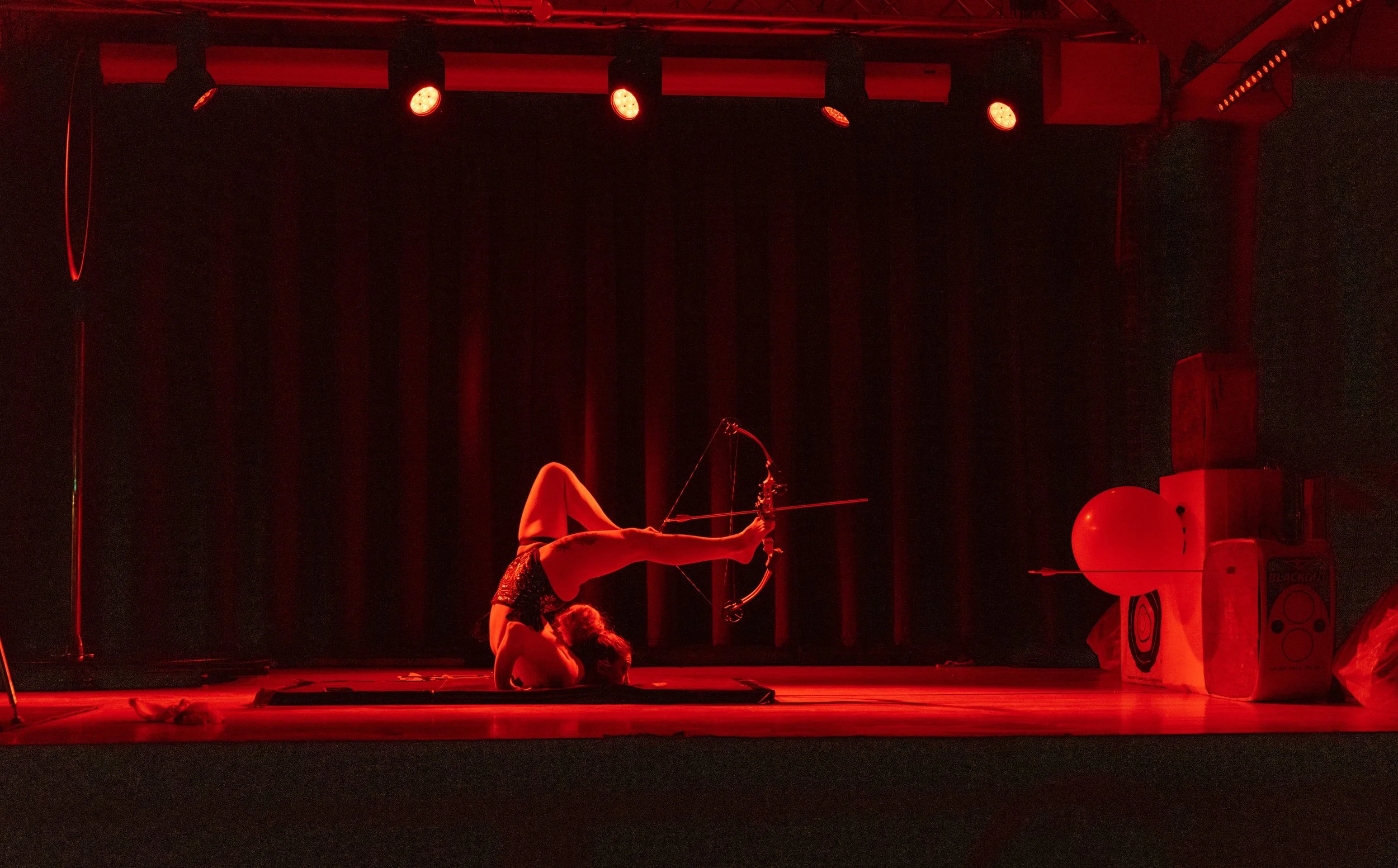 Talia Hazard performing on a stage framed by red curtains