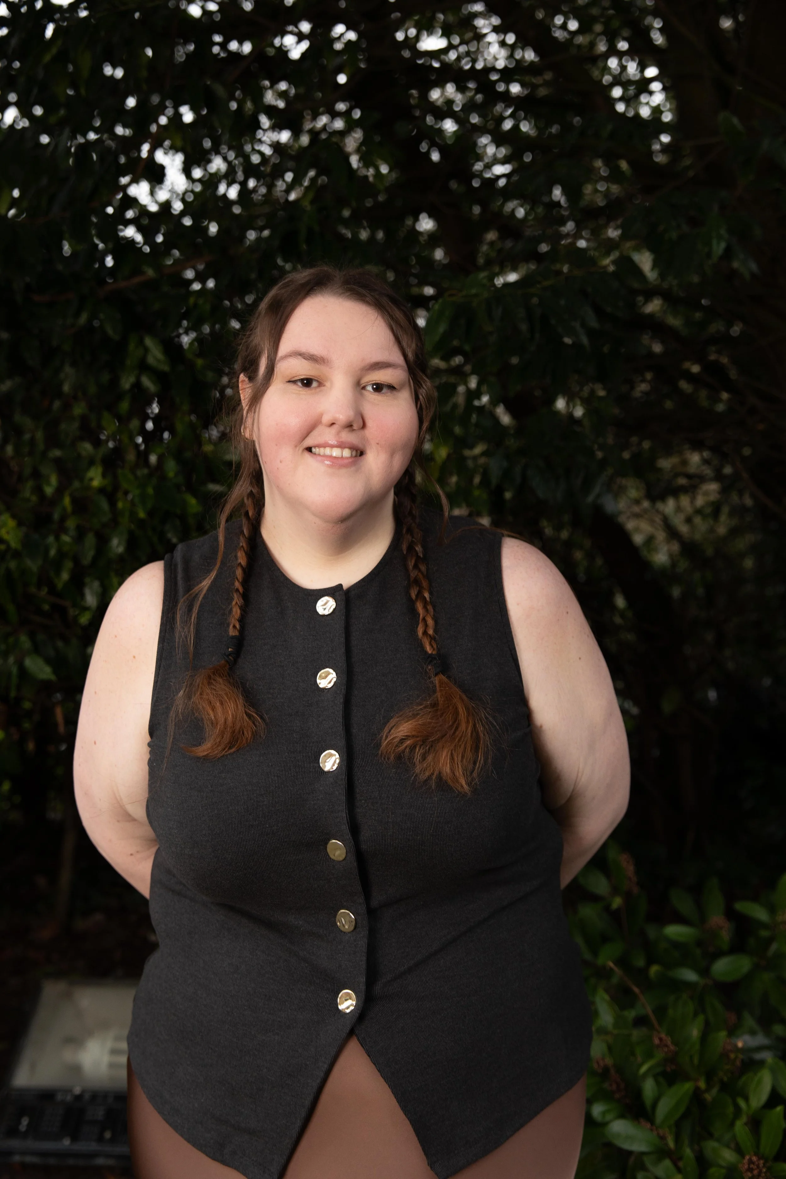 A woman with long, wavy brown hair, light skin, l.