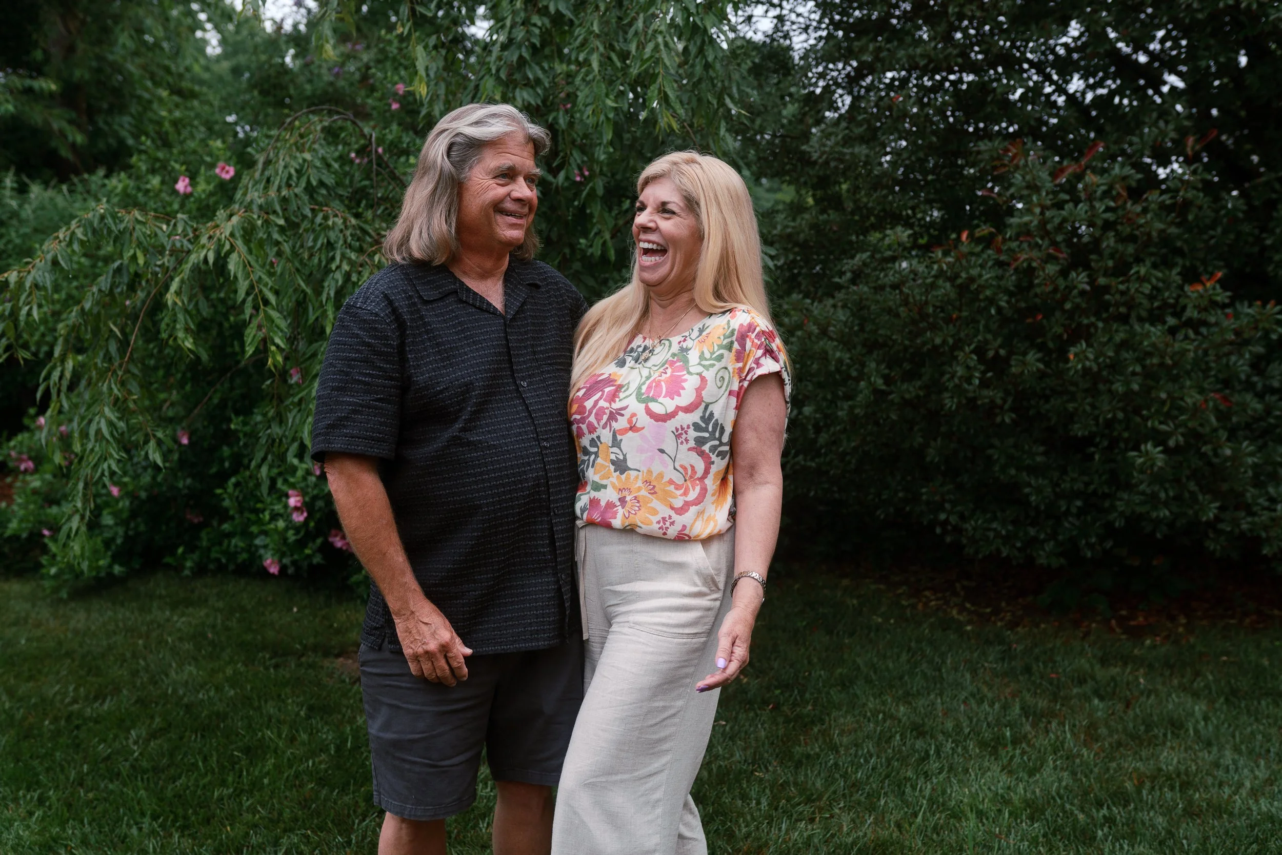 Older couple laughing together in a garden setting at a New Jersey family reunion