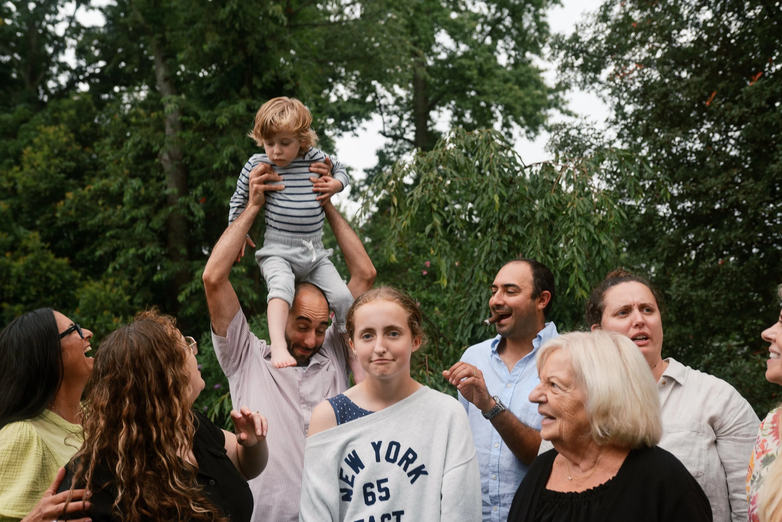 Candid family reunion moment with a father lifting his son overhead among relatives in Haddonfield, NJ